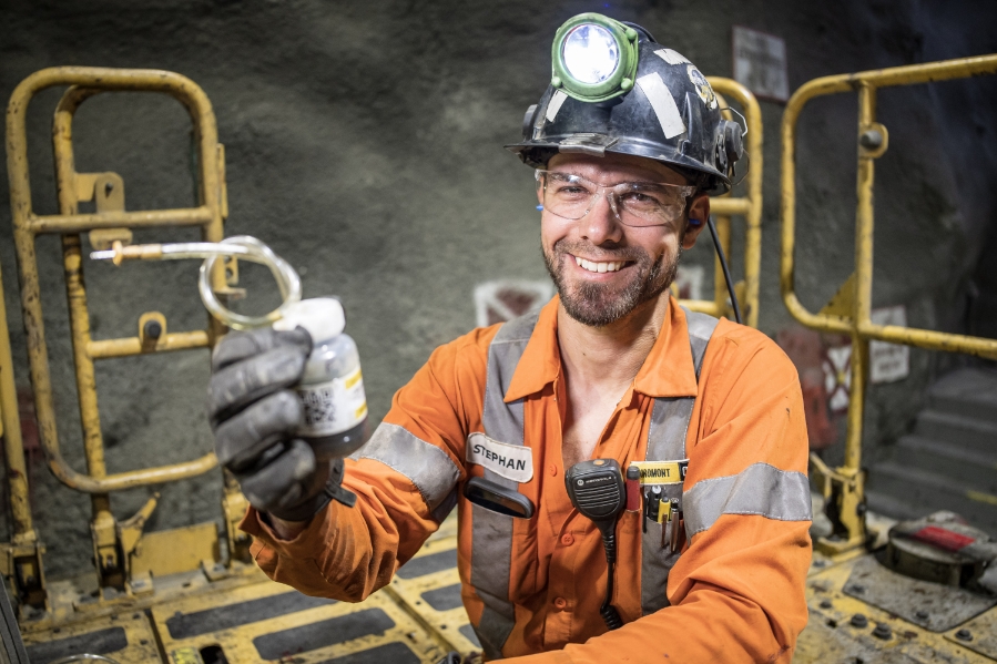 man in construction gear, helmet with light, smiling