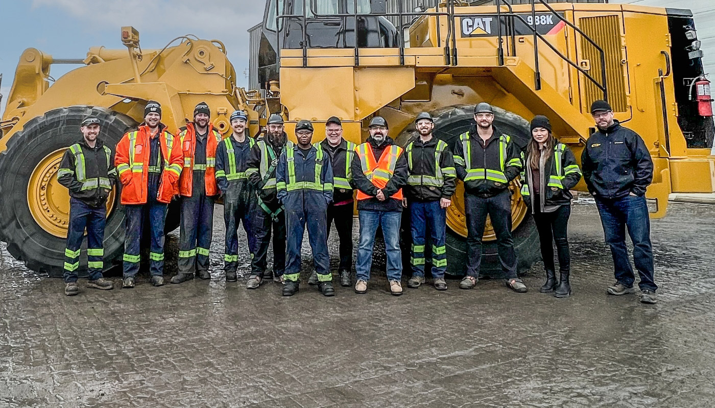 tormont staff in uniform, standing in front of machinery